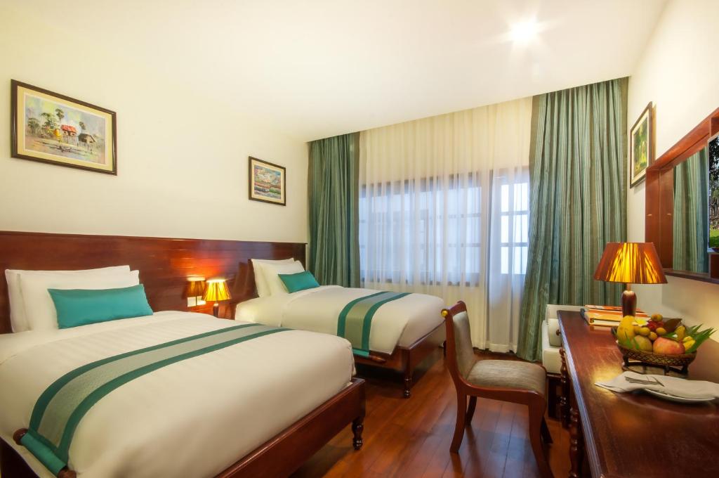 Postel nebo postele na pokoji v ubytování Lotus Blanc Hotel