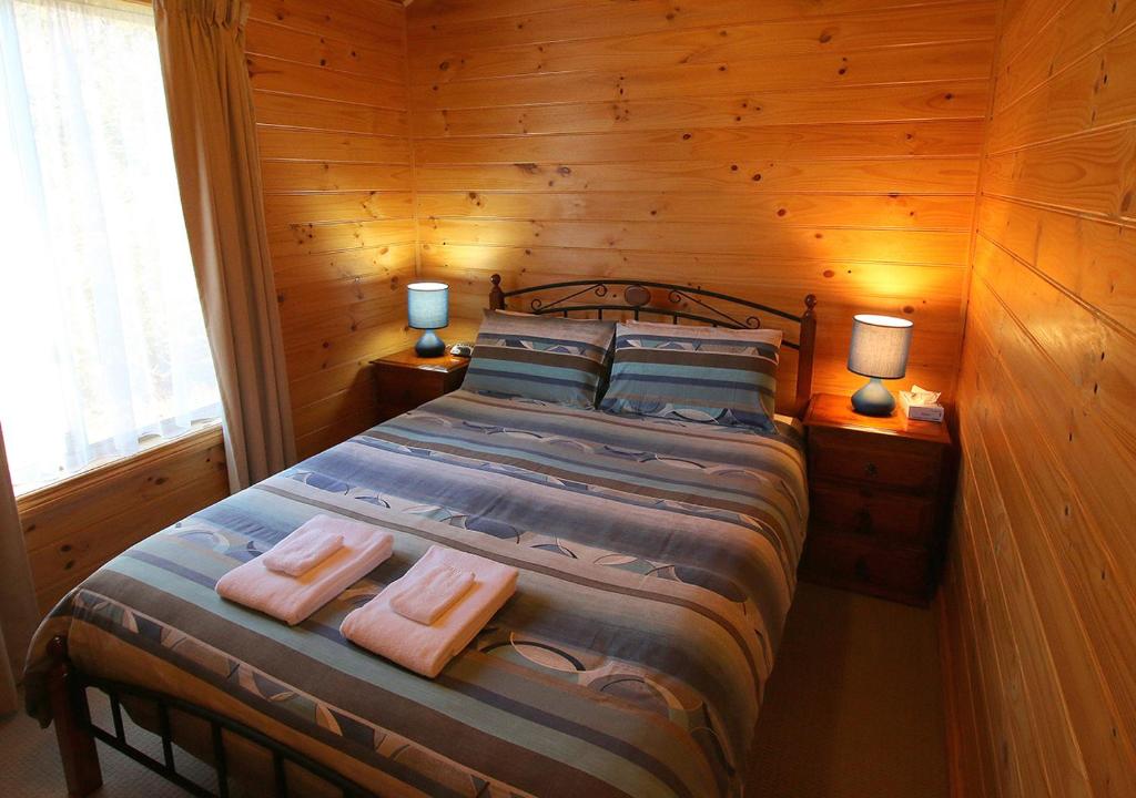 a bedroom with a bed with two towels on it at Beauty Point Tourist Park in Beauty Point