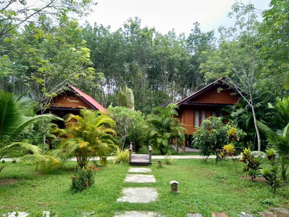 a garden with a bench in front of a house at Najjamee Bungalows in Ko Yao Noi