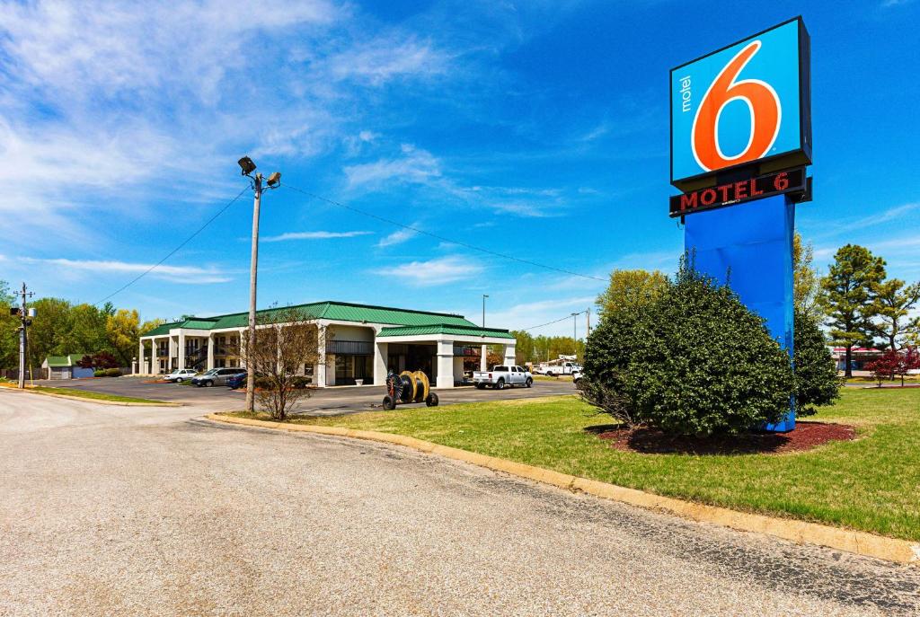 Motel 6-Covington, TN في Covington: علامة الفندق أمام محطة وقود موبيل