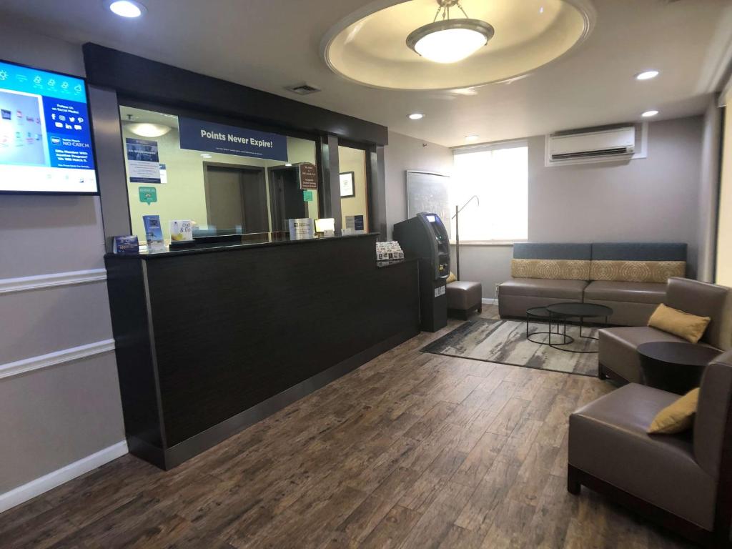 a lobby with a waiting room with couches and a counter at Best Western Jamaica Inn in Queens