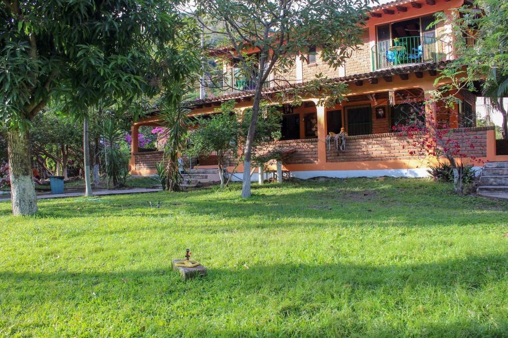 a house in a yard with a bird in the grass at Casa La Potranca in Puerto Vallarta