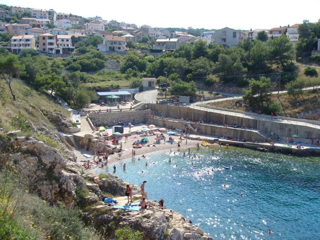 a group of people in the water at a beach at Hotel Vinotel Gospoja in Vrbnik