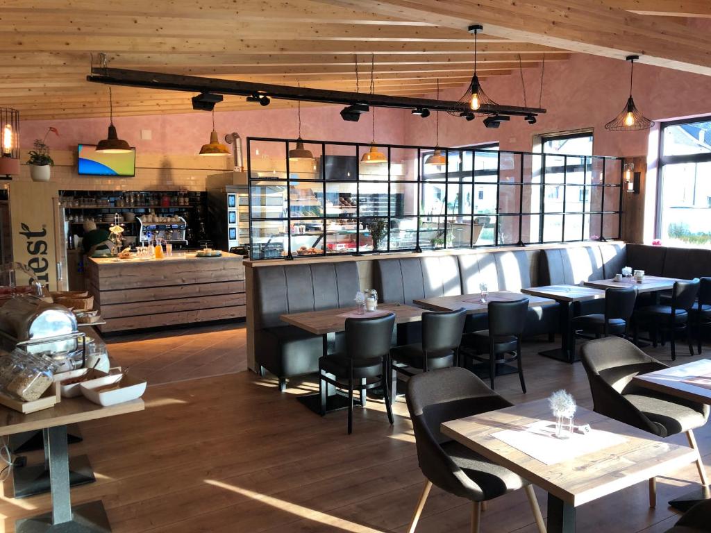 a restaurant with tables and chairs and a kitchen at Carolinger Hüttendorf in Weyer