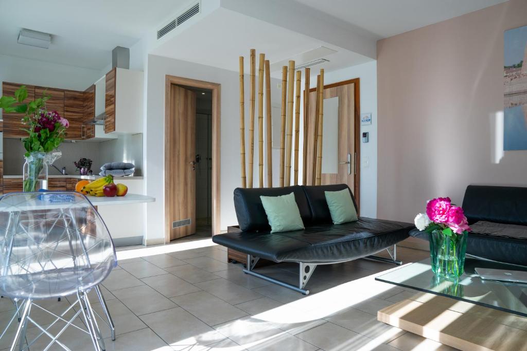 ein Wohnzimmer mit einem schwarzen Sofa und einem Tisch in der Unterkunft first Apart in Erlangen