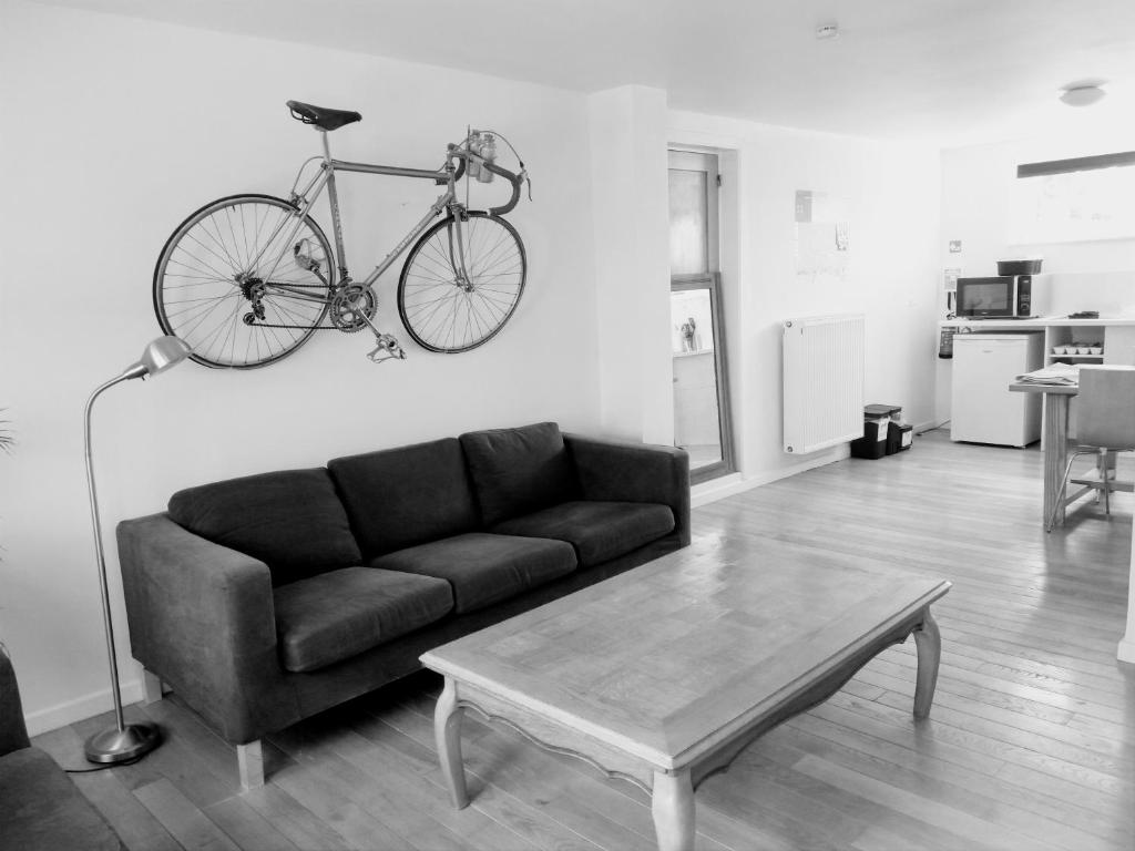 uma sala de estar com um sofá e uma bicicleta pendurada na parede em Studio Flandrien em Oudenaarde