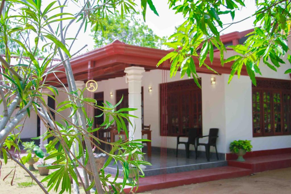 una pequeña casa con techo rojo en Wijesiri Family Guest House, en Sigiriya