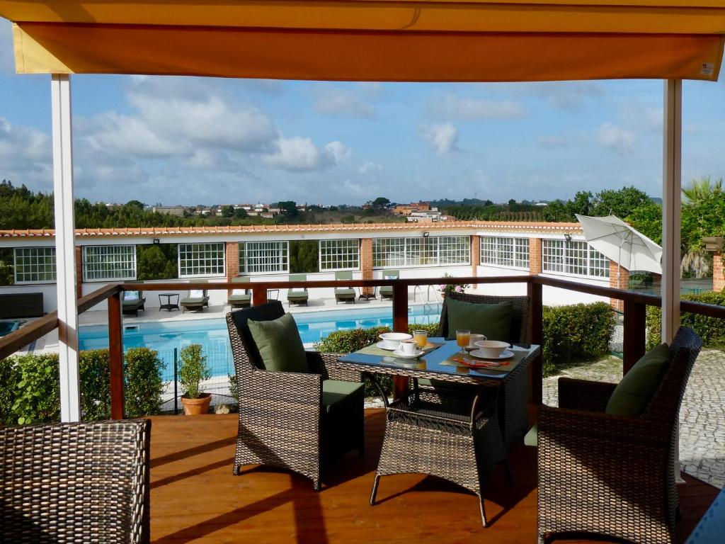 a patio with a table and chairs on a balcony at Vida-Vi, Country House and B&B in Santa Catarina