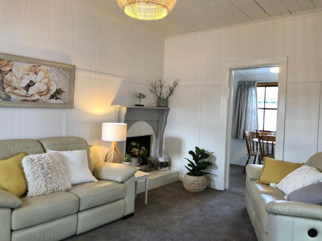 a living room with two couches and a fireplace at Recreation Cottage in Kingston Beach