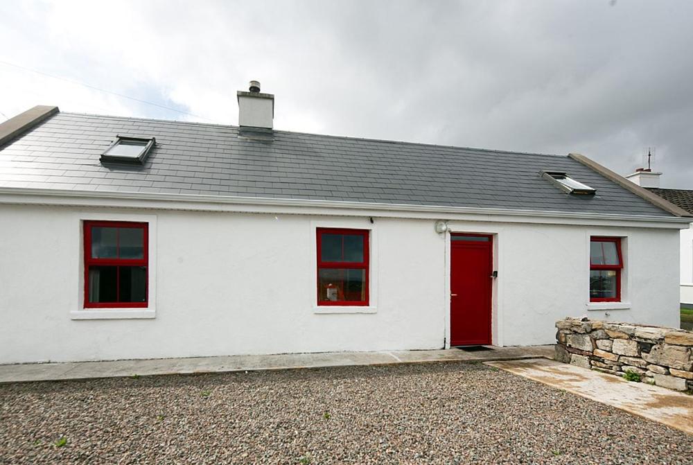 uma casa branca com janelas vermelhas e uma porta vermelha em Johnny Joe's em Achill