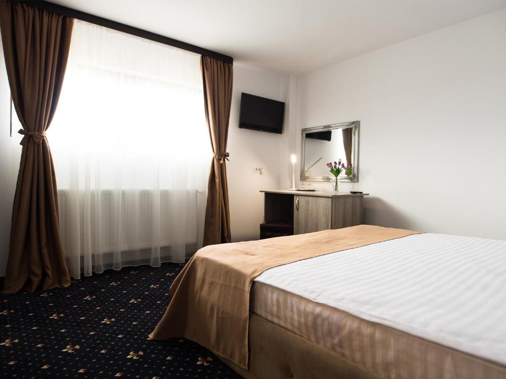 a hotel room with a bed and a window at Pensiunea La Vie in Blaj