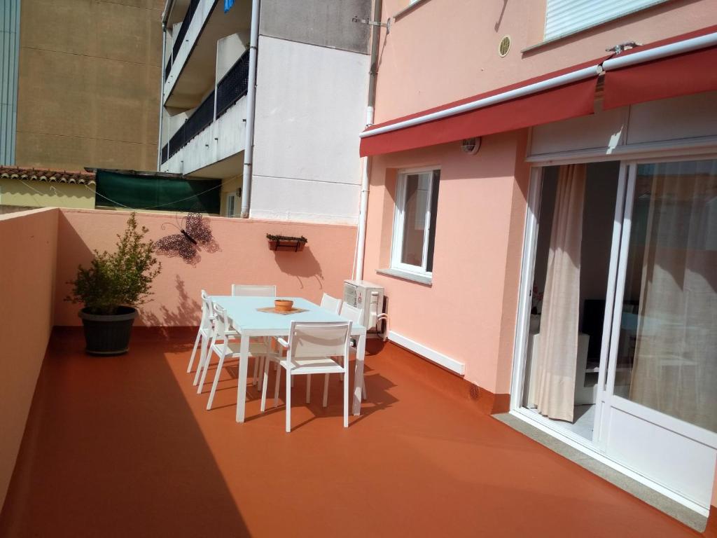 a patio with a table and chairs on a balcony at Apartamento Portosín in Portosin