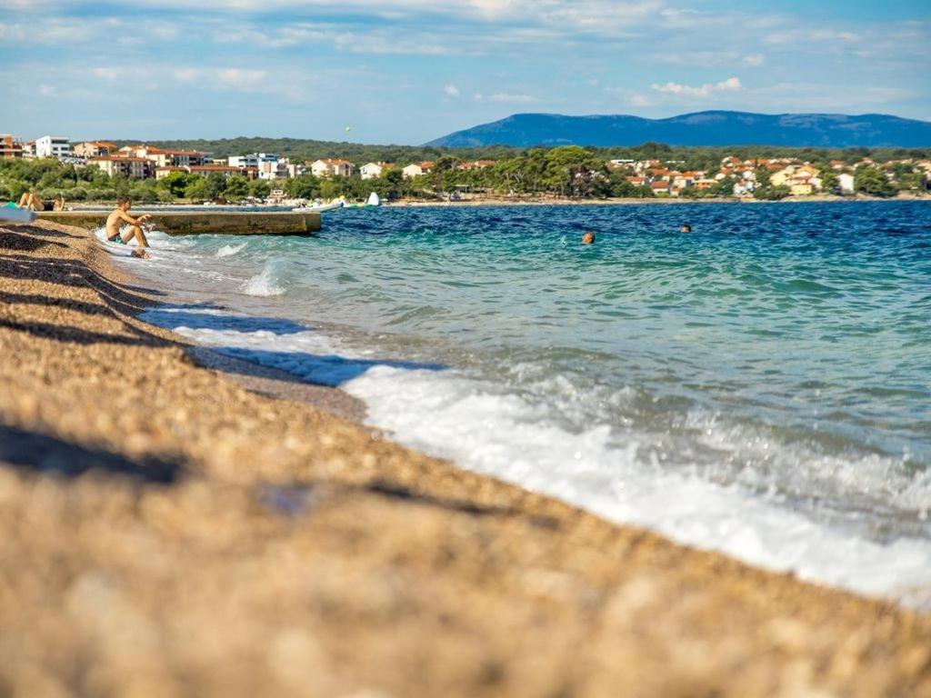 una spiaggia con persone che nuotano in acqua di Luxury Apartments Villa Tunera a Porat