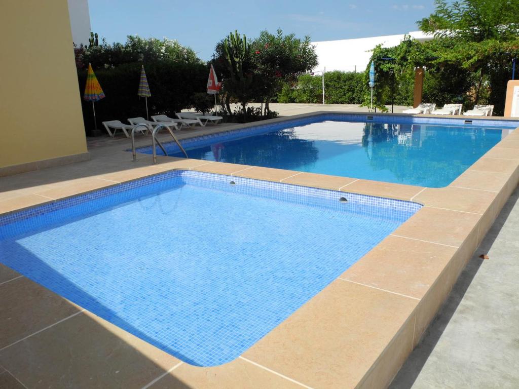 a large swimming pool with blue water at Apartamentos Timon - Emar Hotels in Es Pujols