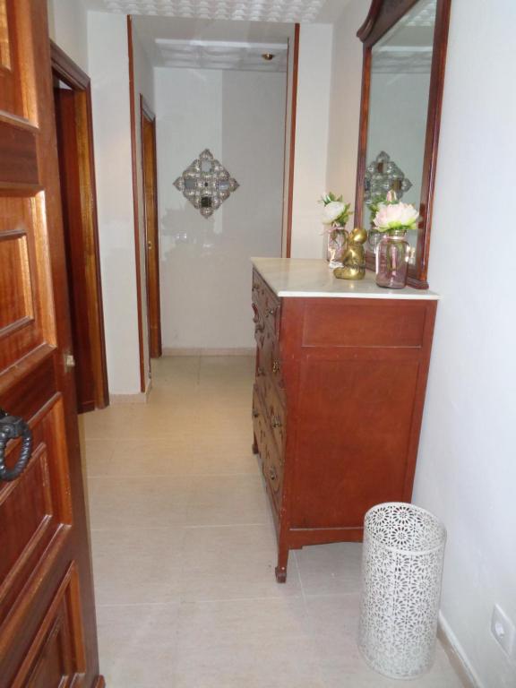 a hallway with a dresser and a mirror at Casa Angel in Cáceres