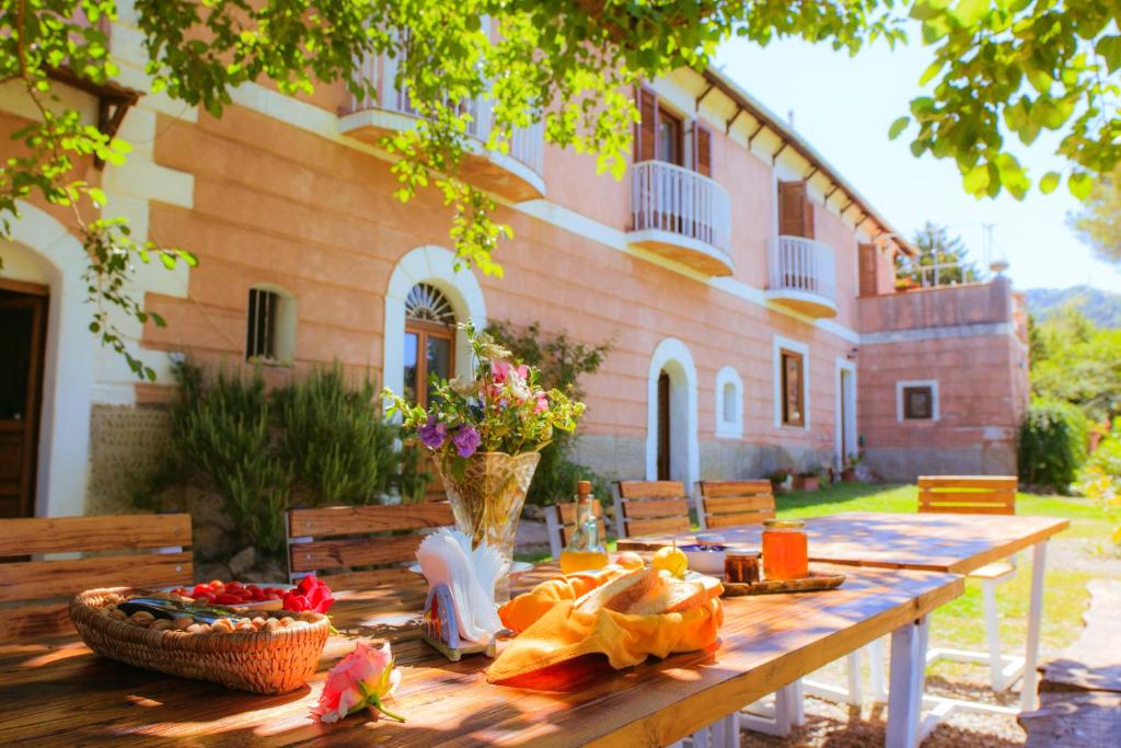 una mesa de madera frente a un edificio en Agriturismo Cuca, en Polizzi Generosa