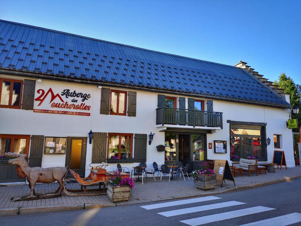 een gebouw in een straat met tafels en stoelen bij Auberge des deux Moucherolles in Corrençon-en-Vercors