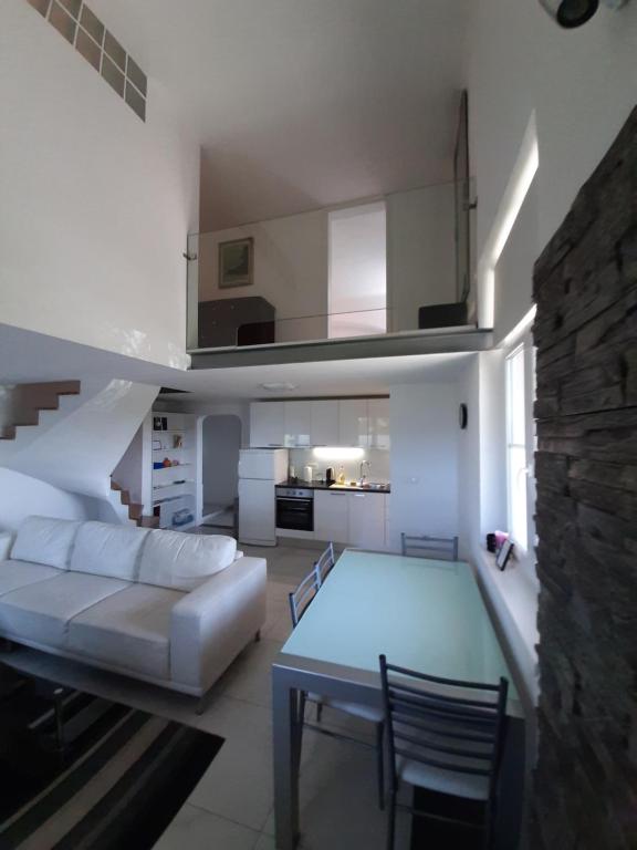 ein Wohnzimmer mit einem weißen Sofa und einem Tisch in der Unterkunft Apartment Osk in Osijek