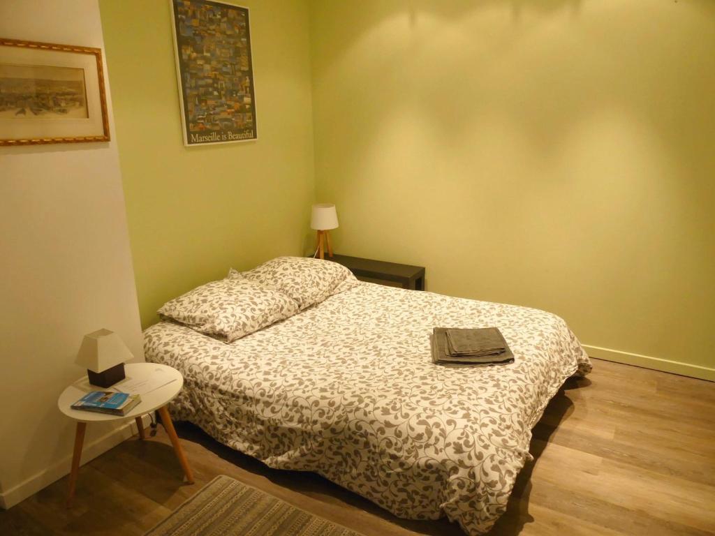 a small bedroom with a bed and a table at Dépendance sainte Anne in Marseille