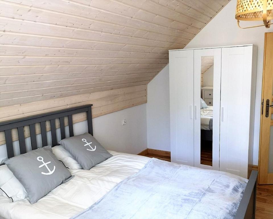 ein Schlafzimmer mit einem Bett mit zwei Kissen darauf in der Unterkunft Przystanek Wczasy in Jastarnia