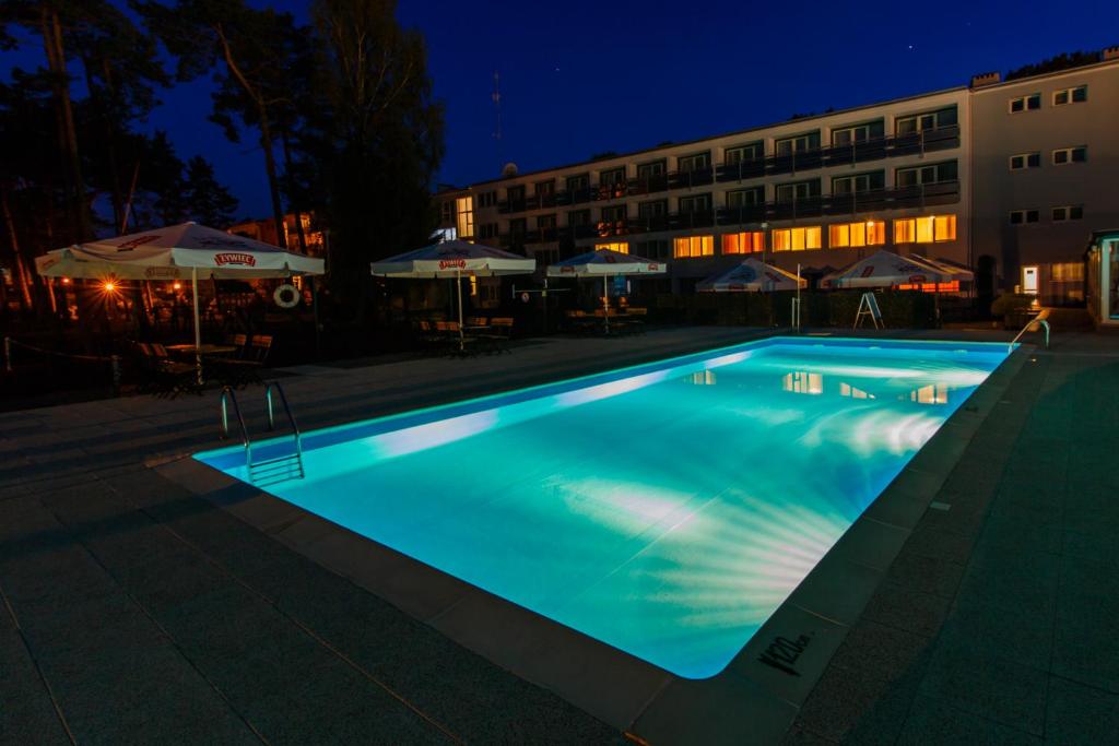 a swimming pool at night with a hotel at Baltic Inn in Pogorzelica