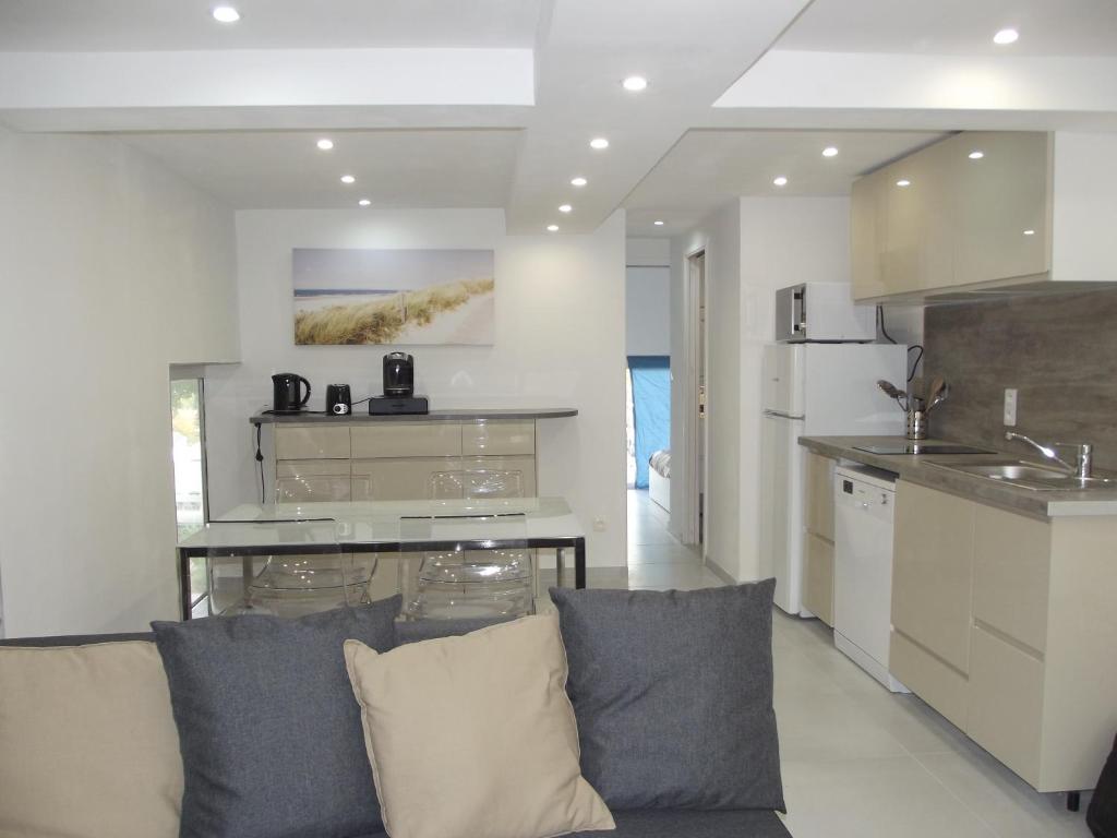 ein Wohnzimmer mit einem Sofa und einer Küche in der Unterkunft P2 CABINE - LA GRANDE-MOTTE in La Grande-Motte