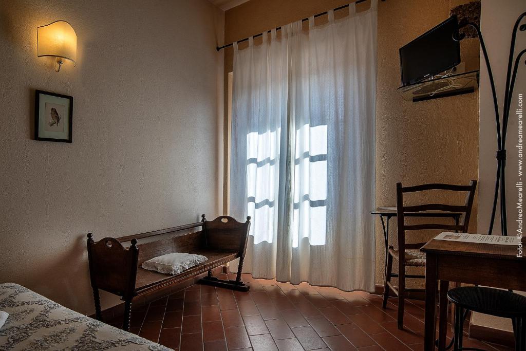 sypialnia z łóżkiem i oknem ze stołem w obiekcie Hotel Scilla w mieście Sovana