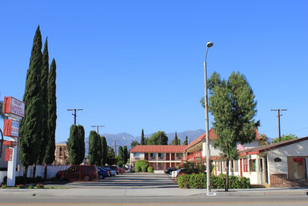 uma rua numa pequena cidade com estacionamento em Valley Hotel em Rosemead