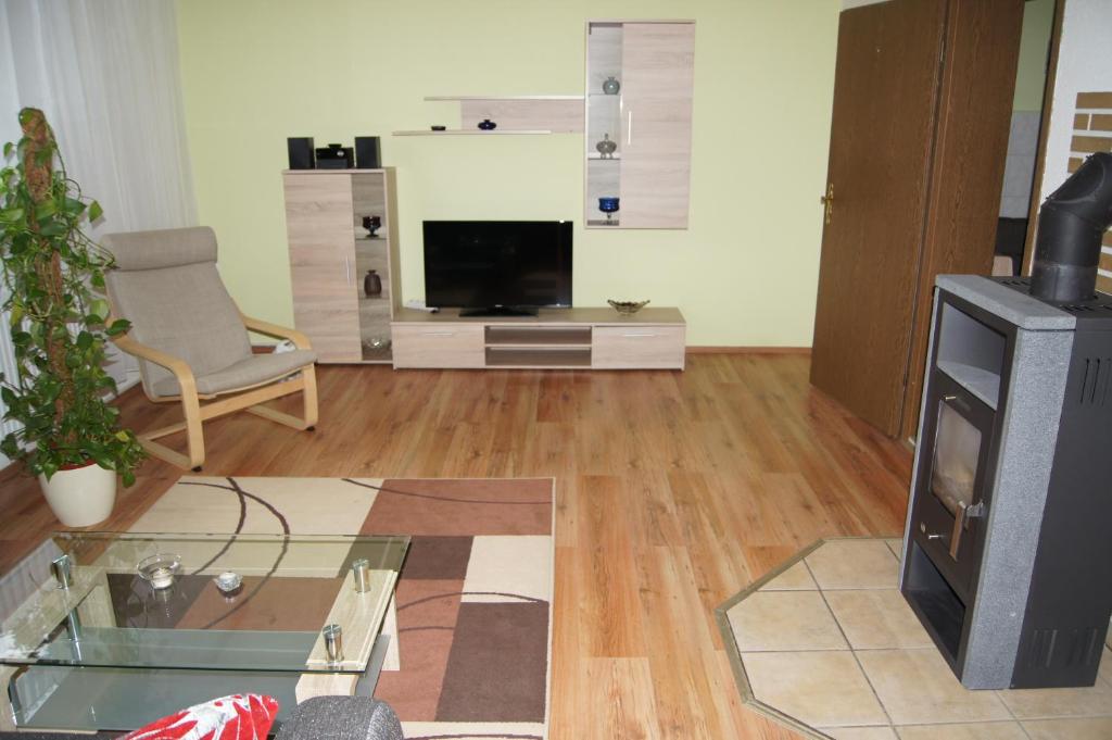 a living room with a tv and a glass table at Ferienwohnung Feldberger Seenlandschaft in Neuhof