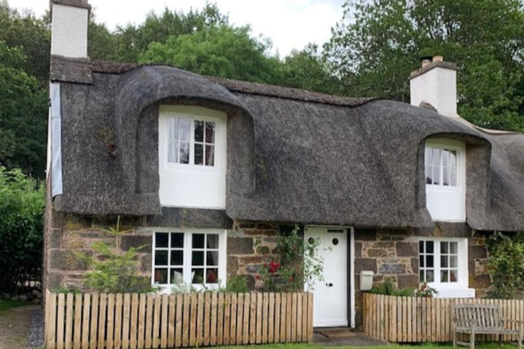 an old stone house with a thatched roof at Glencroft A Fairytale Highland Cottage in Aberfeldy