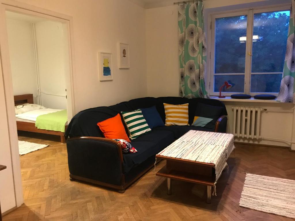 - un salon avec un canapé noir et une table dans l'établissement Mal's Apartment, à Łódź