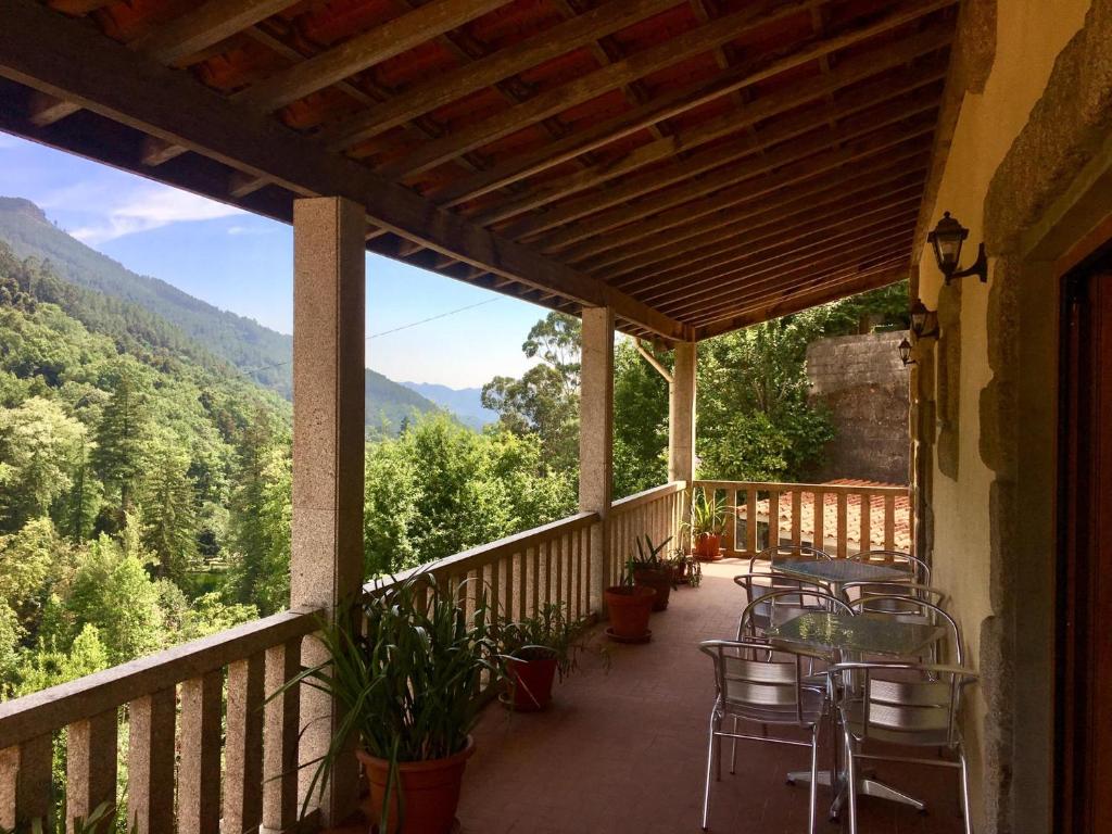 a balcony with tables and chairs and a view of the mountains at Casa do Pedrógo in Geres