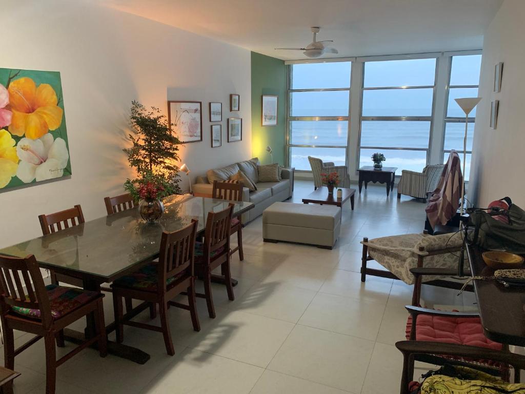 un soggiorno con tavolo e divano di Apto Pitagueiras - Vista incrível a Guarujá
