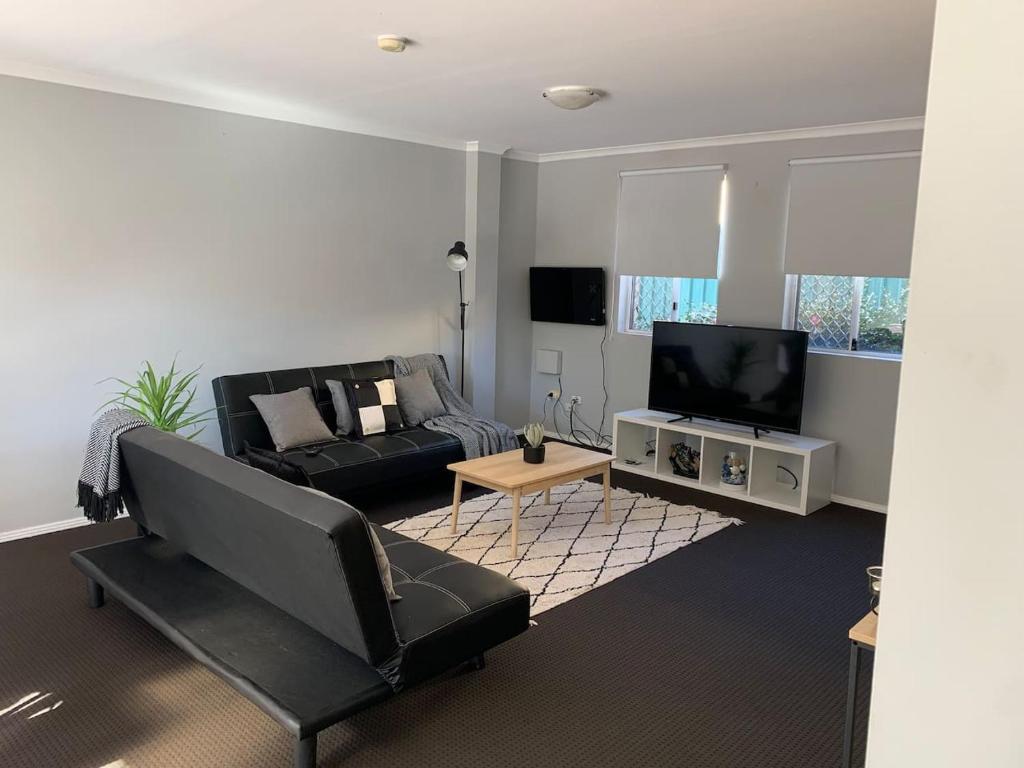 a living room with a couch and a tv at Cozy 3BR Townhouse in Liverpool CBD with parking in Liverpool