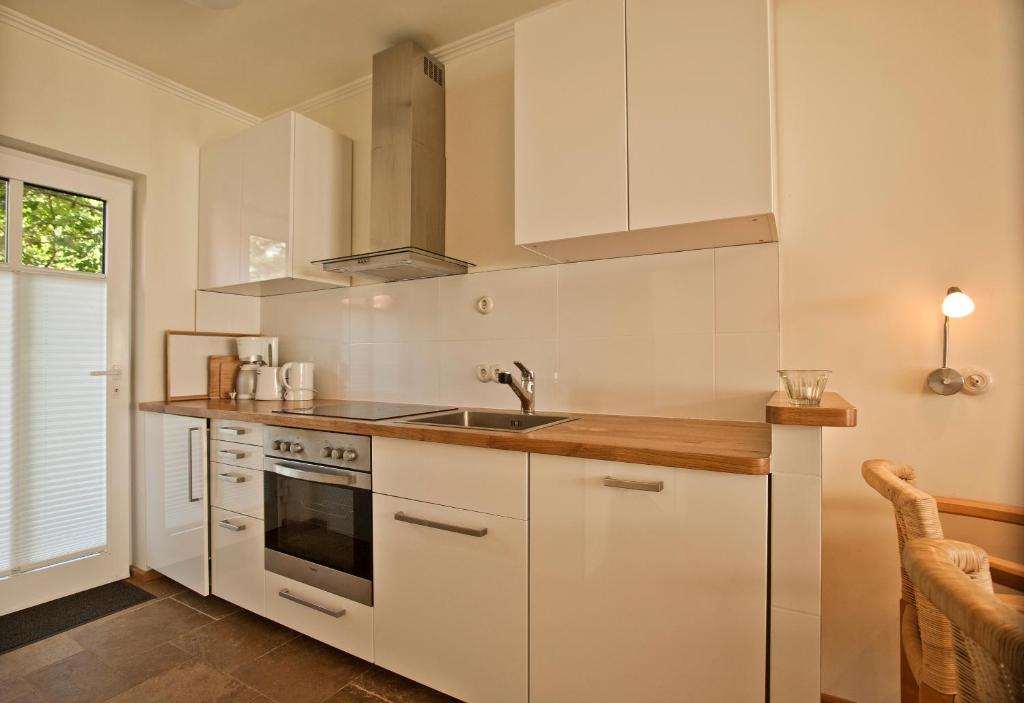 a kitchen with white cabinets and a sink at Ferienhäuser Südwind in Hiddensee