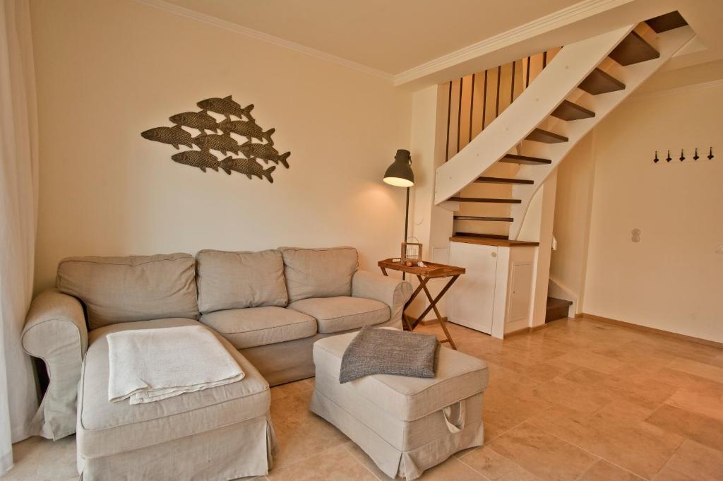 a living room with a couch and a staircase at Ferienhäuser Südwind in Hiddensee