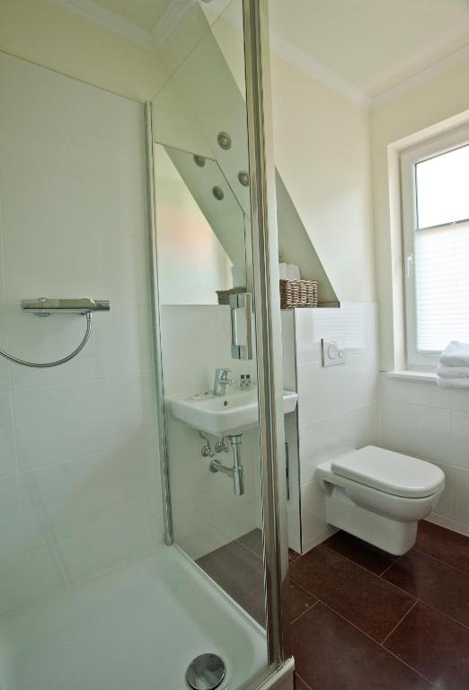 a bathroom with a shower and a toilet and a sink at Ferienhäuser Südwind in Hiddensee