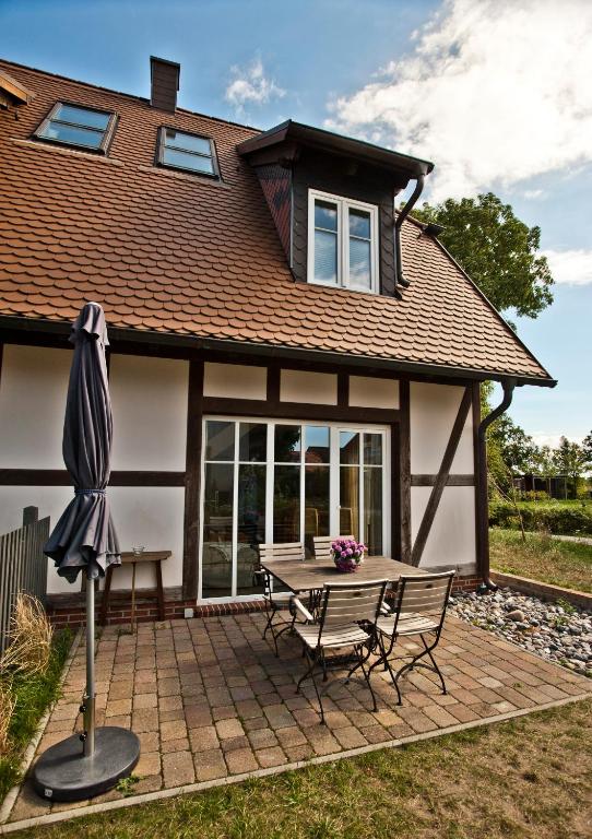 a house with a picnic table and an umbrella at Ferienhäuser Südwind in Hiddensee