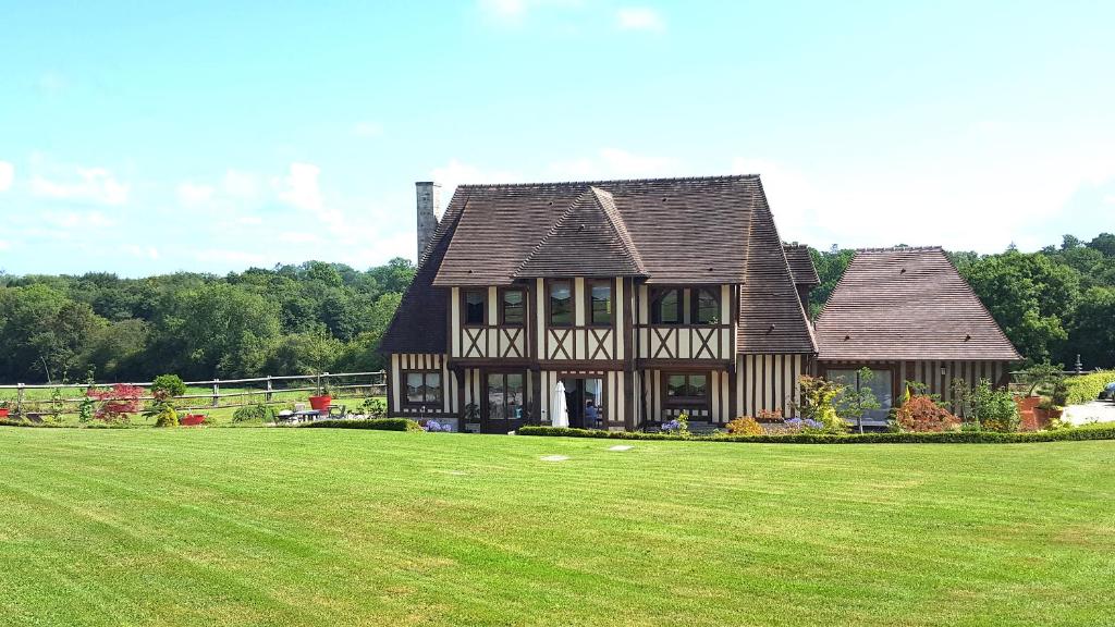 une grande maison avec une grande pelouse dans l'établissement L'Herbe aux Vaches, à Saint-Pierre-Azif