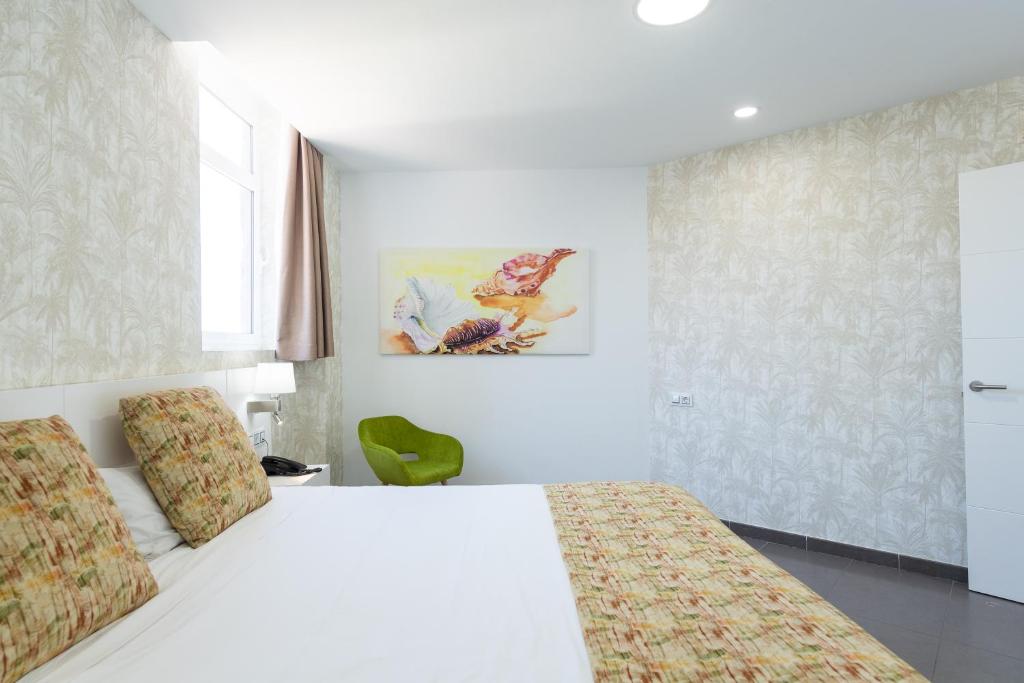 a white bedroom with a bed and a window at Holiday Club Vista Amadores in Amadores