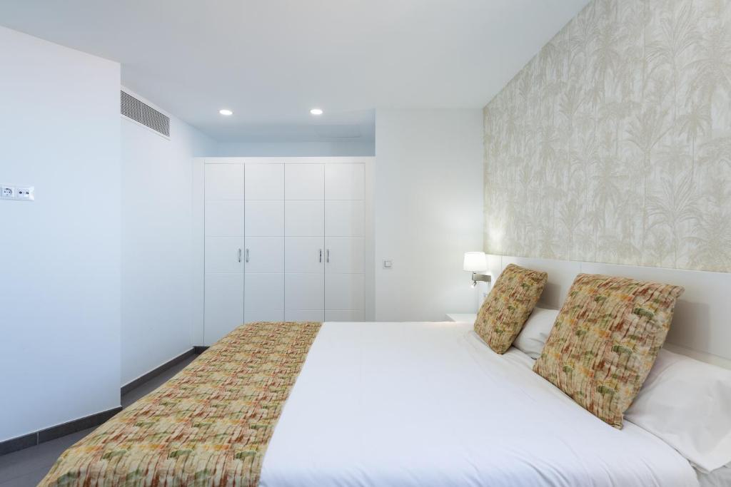 a bedroom with a white bed with two pillows at Holiday Club Vista Amadores in Amadores