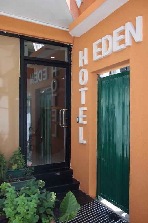 une porte verte sur le côté d'un bâtiment dans l'établissement Eden hotel, à Tirana
