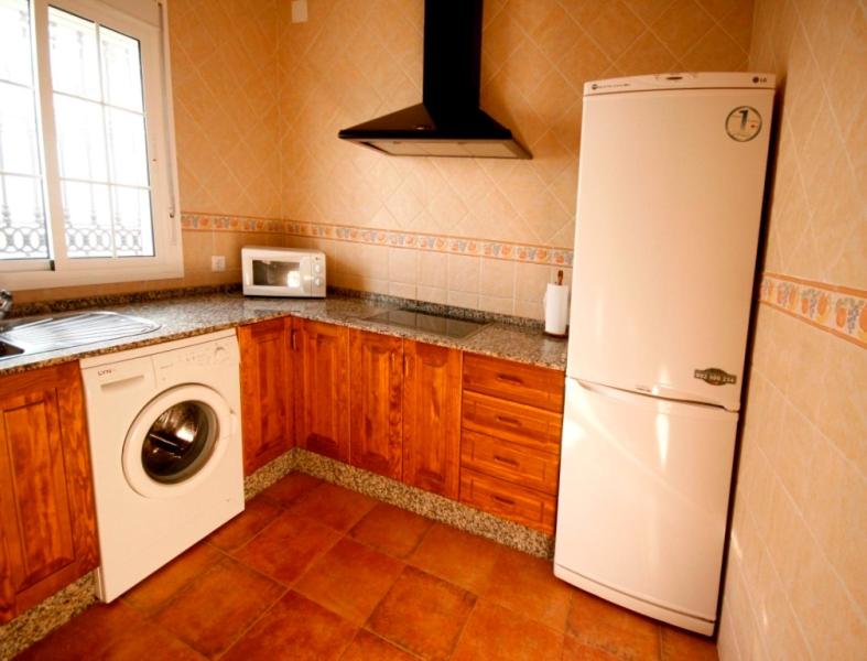 a kitchen with a white refrigerator and a washing machine at Casa Rural El Limonero in Los Naveros