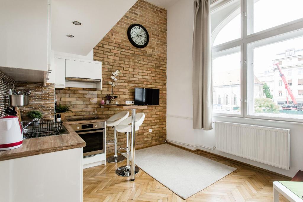 a kitchen with a clock on a brick wall at Dream Home in The Walking Street in Budapest