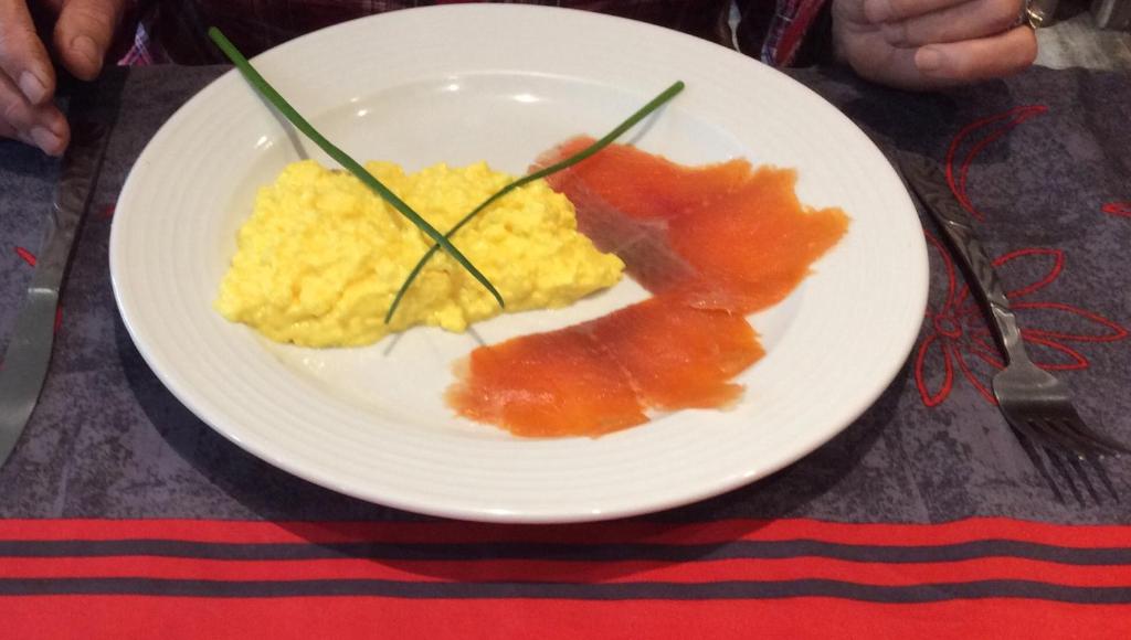 a plate of eggs and fruit on a table at L'Ancienne Boulangerie in Collinée