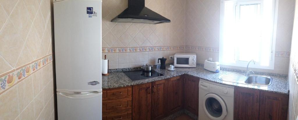 a small kitchen with a sink and a refrigerator at Casa Rural El Limonero in Los Naveros