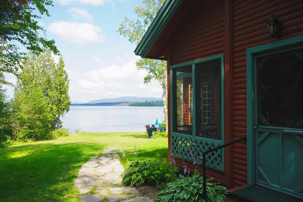 a red house with a view of a lake at Le Cent in Saguenay