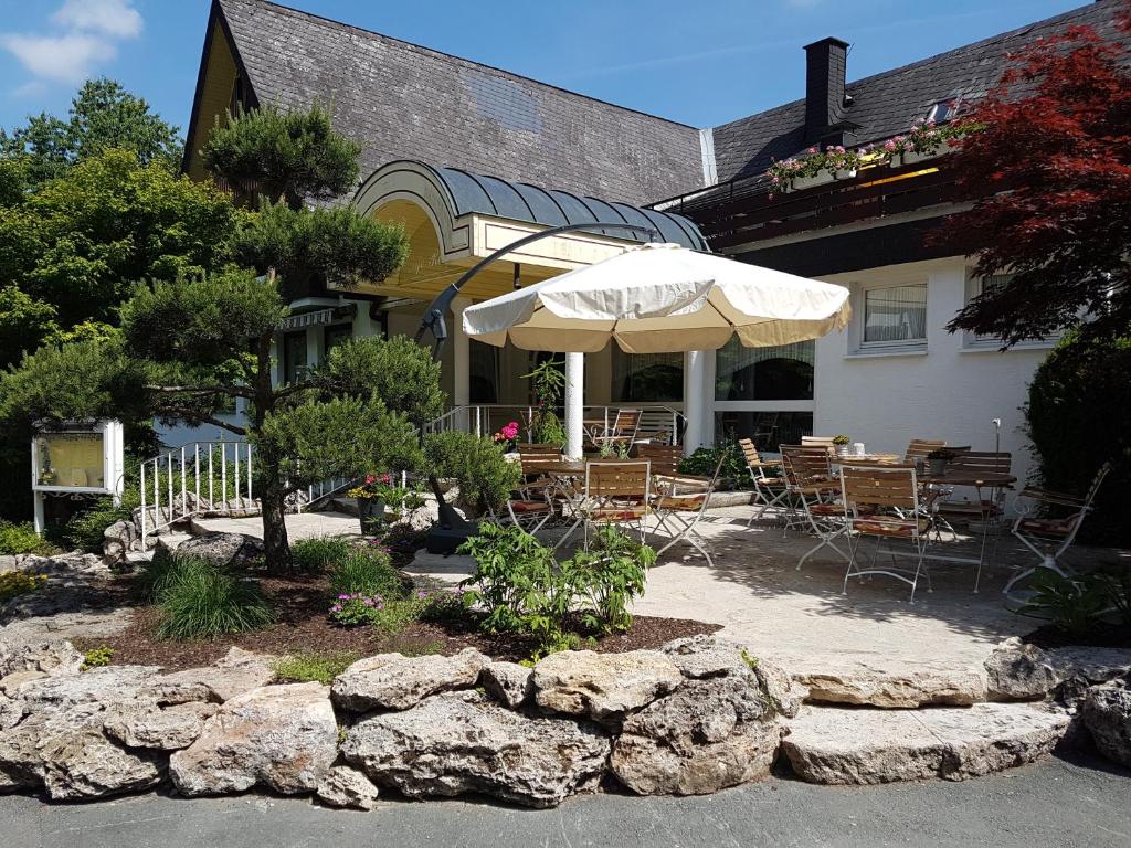 ヴィリンゲンにあるUrlaubs- und Wellnesshotel Friederikeの建物の前にパティオ(テーブル、パラソル付)
