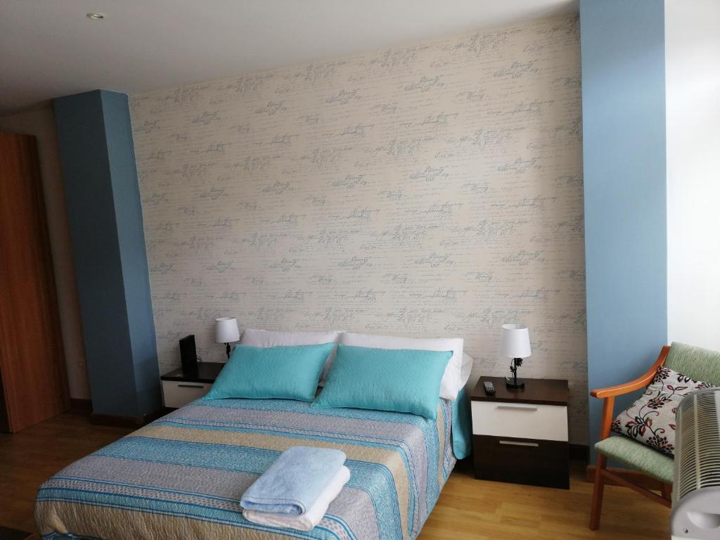 a bedroom with a bed with two towels on it at Apartamentos San Roque in Ribadeo