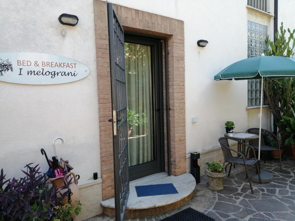 a door to a building with a table and an umbrella at I Melograni in Sora